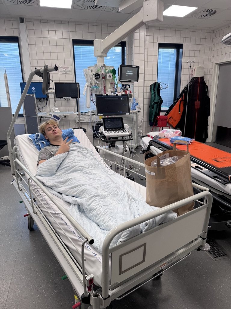 Knud-Magnus på hospitalet efter styrtet, med et V-tegn